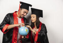 pair happy students gown looking globe white